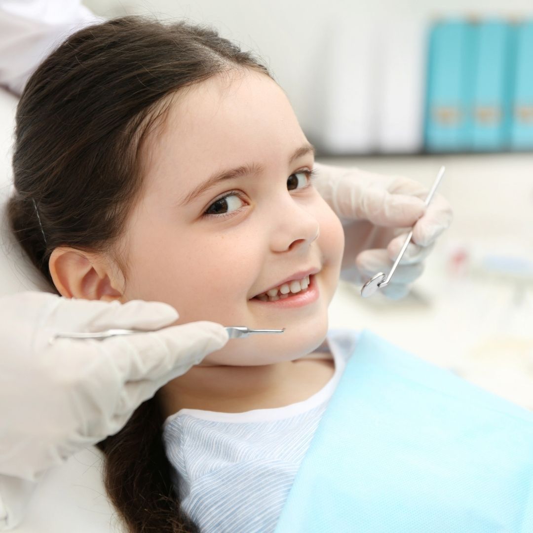 child smiling at camera before dental cleaning