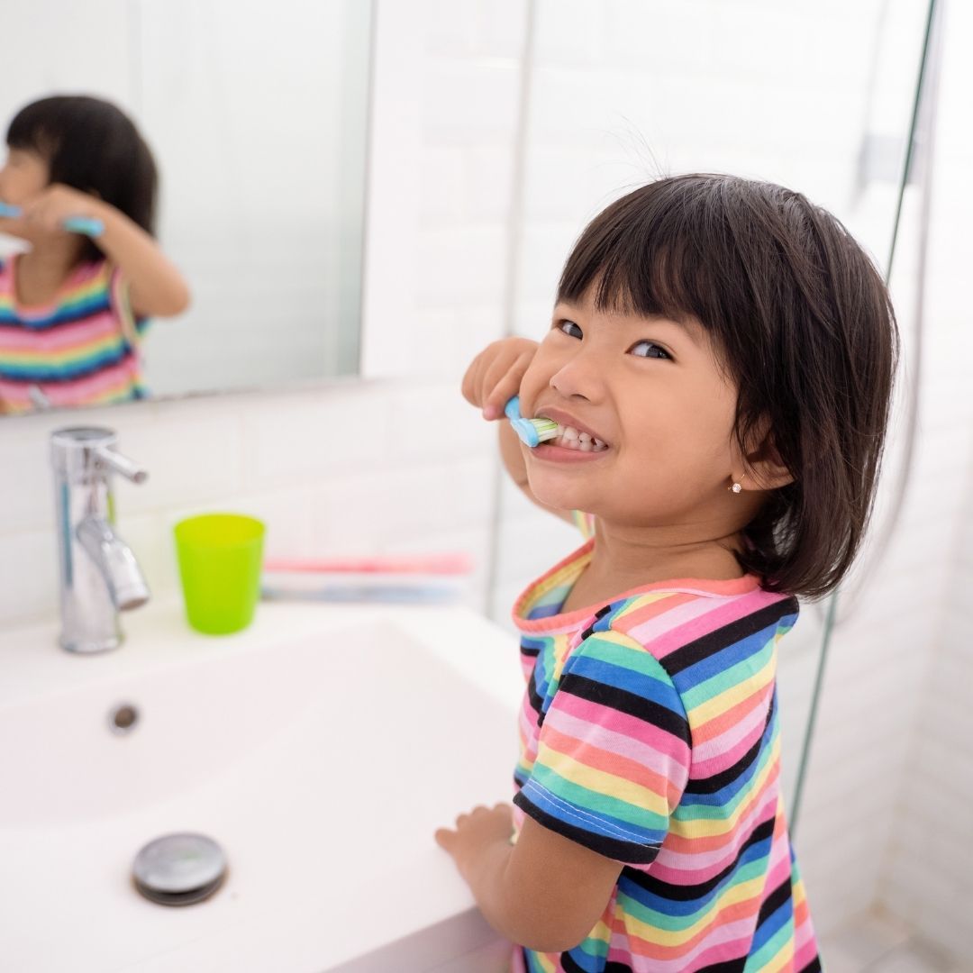 child brushing teeth in bathroom
