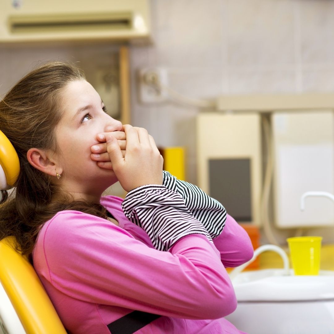 child with hands over mouth