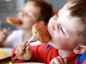 A child eating something on a fork