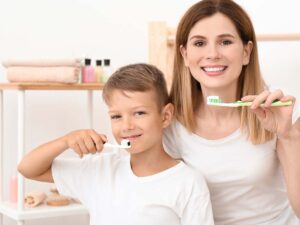 A mother brushing her teeth with her son