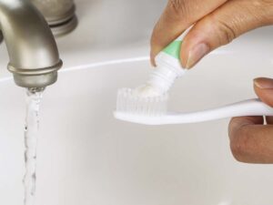 A child putting toothpaste on their toothbrush