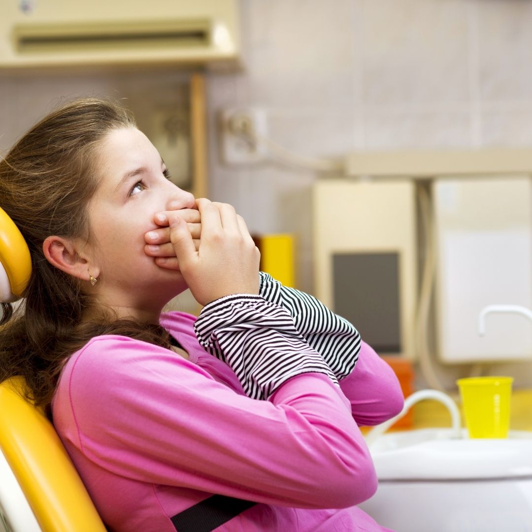 child with hands over mouth